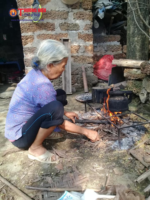 Bà cụ Lan đang nấu bữa cơm đạm bạc cho gia đình.